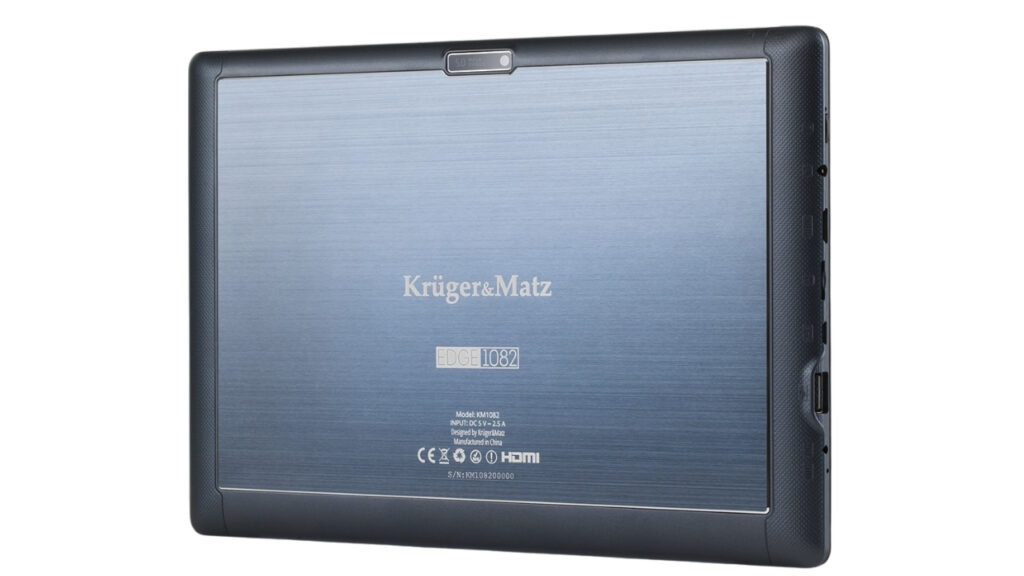 Back view of a Krüger & Matz Edge 1082 tablet with blue brushed-metal back, logo centered, camera at top edge, and side ports visible on the right edge.