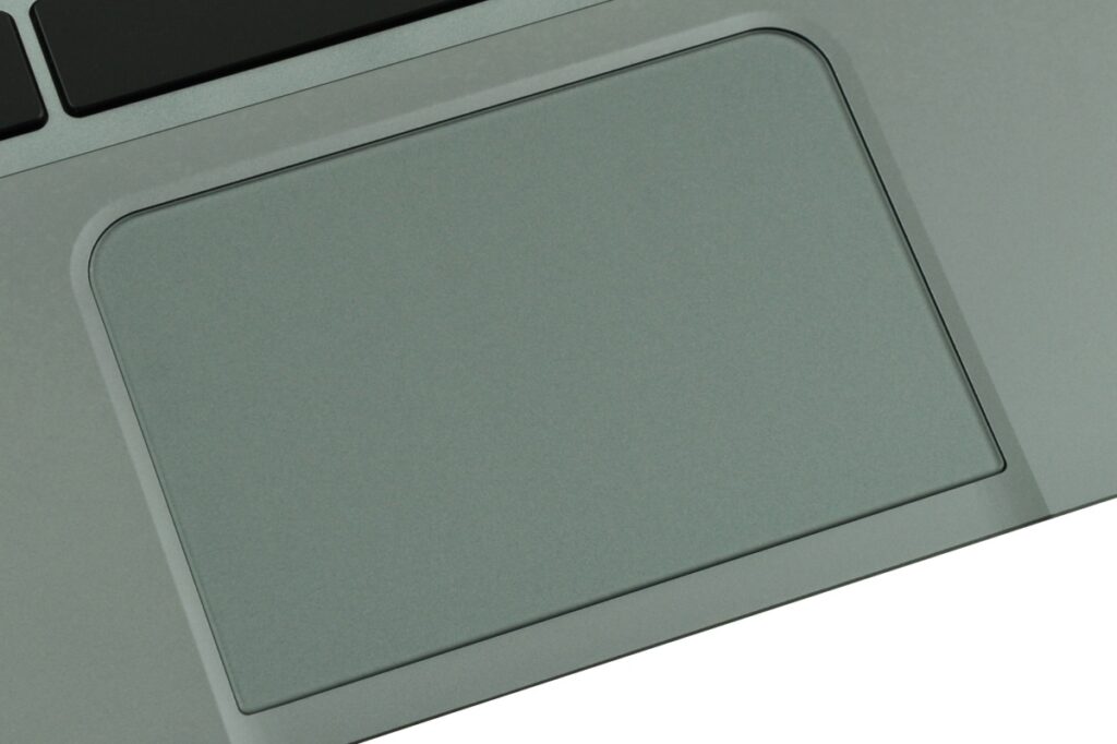 Close-up of a gray laptop trackpad on a silver aluminum body, without visible buttons.