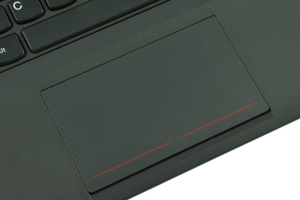 Close-up of a black laptop touchpad with two red lines along the bottom edge.