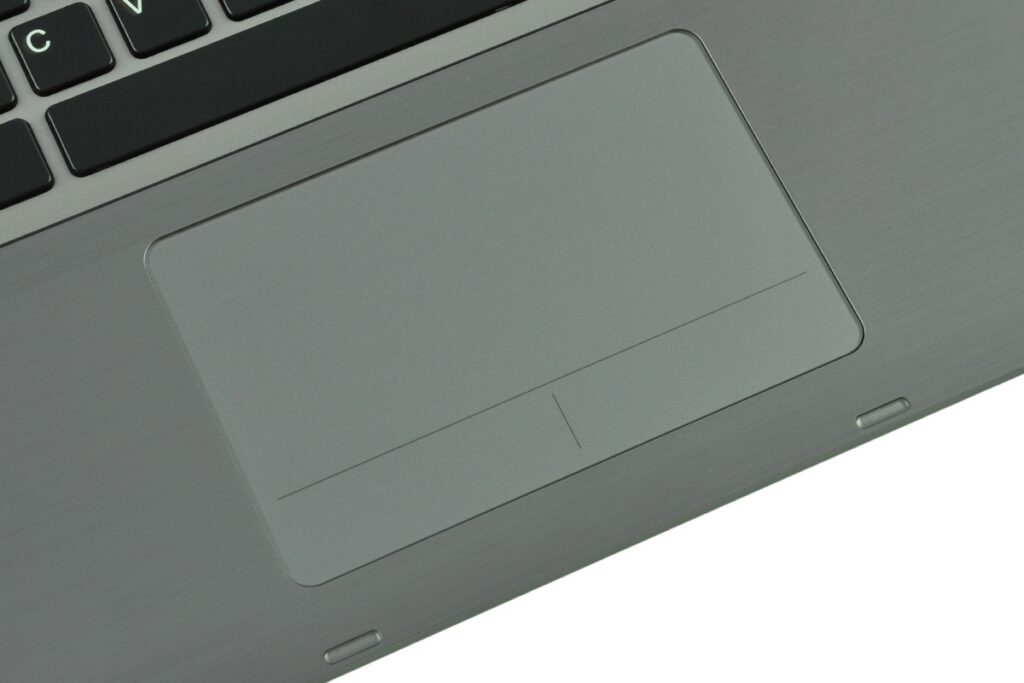 fujitsu-lifebook-t904-lk_130544 - lab-kuzniewski.pl - Testy laptopów, recenzje i porównania Close-up of a gray metallic laptop touchpad on a laptop keyboard base, showing a large rectangular pad with a subtle divider line and edge buttons.