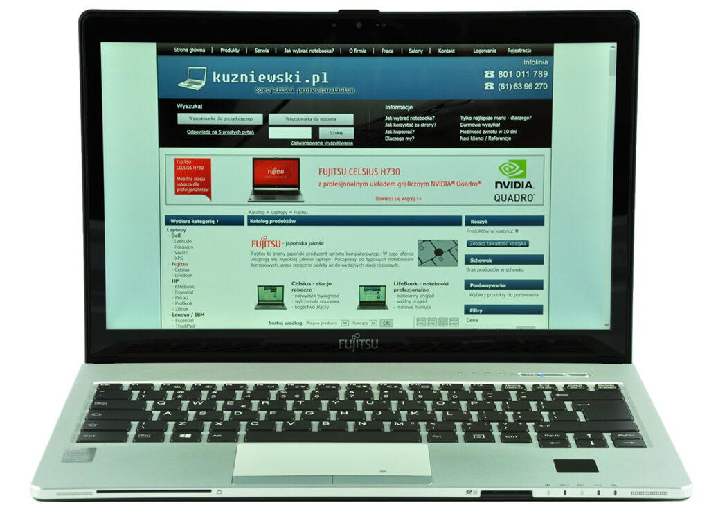 Open silver laptop displaying a Polish tech site with product banners and navigation are visible on the screen, including Fujitsu and Nvidia ads.
