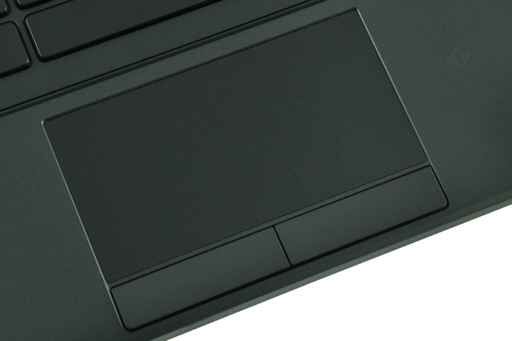 dell-latitude-e5250-ca01_131699 - lab-kuzniewski.pl - Testy laptopów, recenzje i porównania Close-up of a dark laptop touchpad with two separate buttons beneath it on the palm rest area.