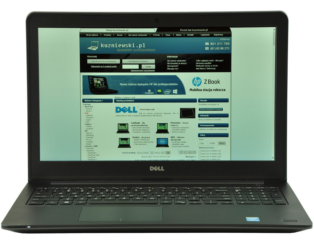 Dell laptop showing the kuzniowski.pl homepage on its screen, with a blue header and product listings visible.