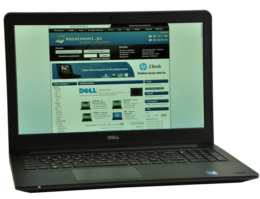 Dell laptop open with a website displayed on the screen, featuring a blue header and navigation menu.