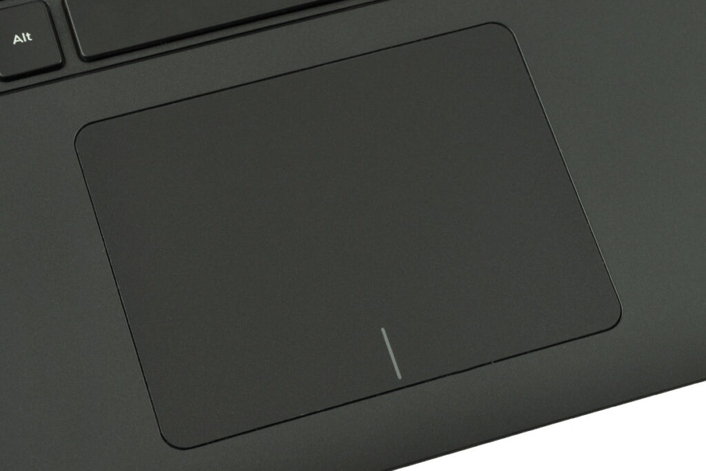 Close-up of a matte black laptop trackpad with a small vertical light cue near the bottom edge and part of the keyboard (Alt key) visible.