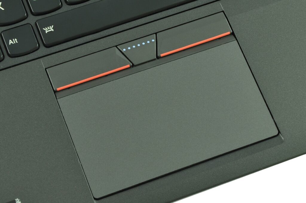 lenovo-thinkpad-yoga-14_131823 - lab-kuzniewski.pl - Testy laptopów, recenzje i porównania Close-up of a laptop touchpad with red left/right buttons above it and a small blue indicator on a dark keyboard edge.