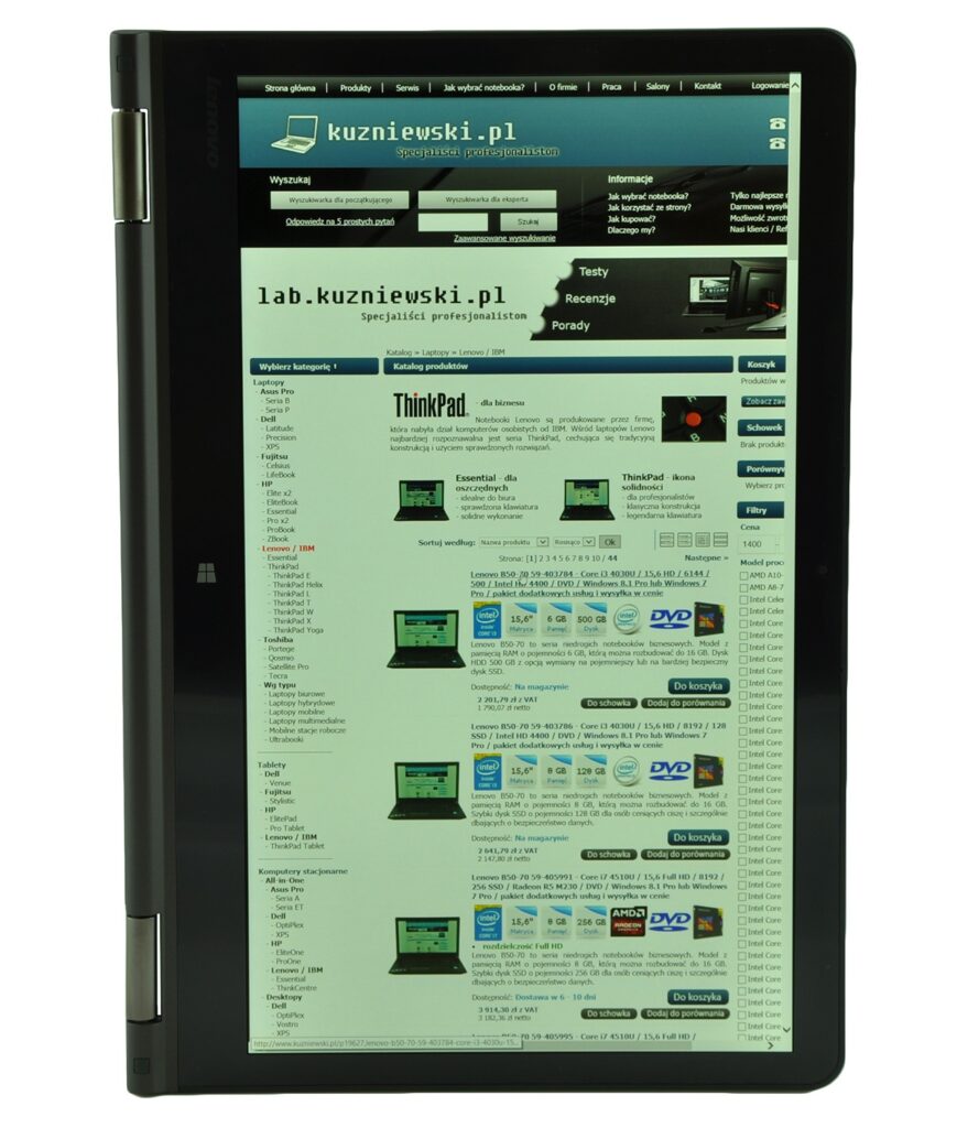 lenovo-thinkpad-yoga-14_131828 - lab-kuzniewski.pl - Testy laptopów, recenzje i porównania Tablet displaying kuzniewski.pl website with blue header and product listings on screen
