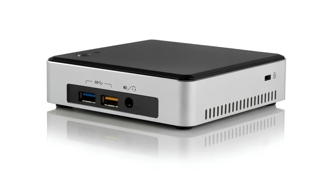 Silver mini PC with black top; front panel shows blue USB 3.0 port, orange USB 2.0 port, and a headphone jack.