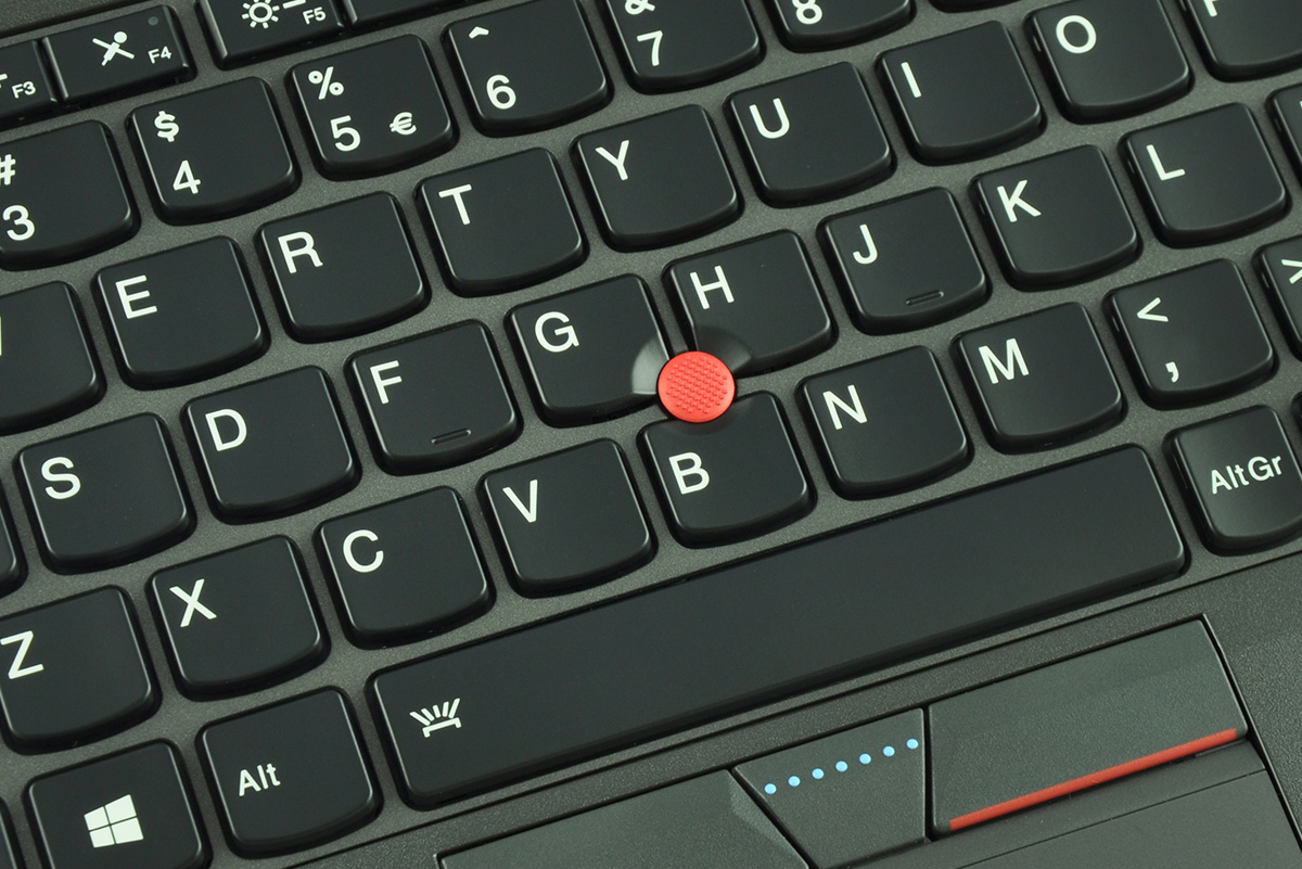 laptop-lenovo-thinkpad-x250-6 - lab-kuzniewski.pl - Testy laptopów, recenzje i porównania Close-up of a laptop keyboard showing a red trackpoint nub between the G and H keys with a touchpad below.
