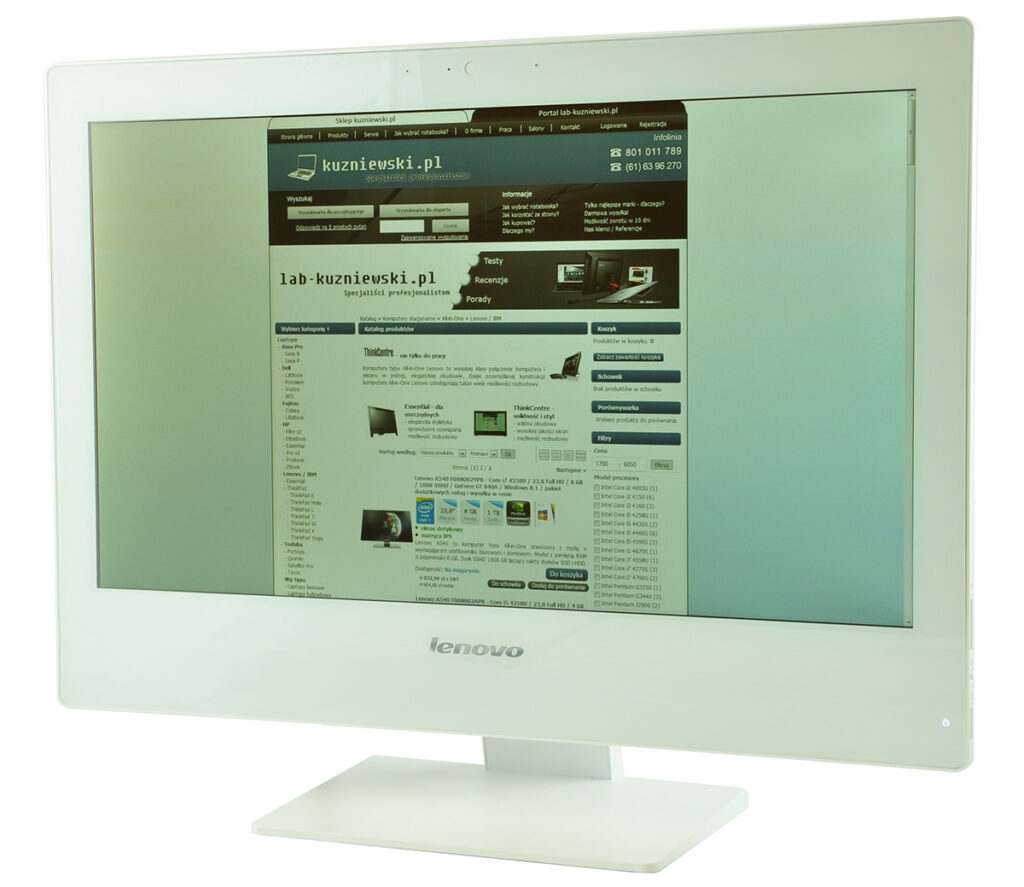 White Lenovo monitor on a stand showing a Polish tech website homepage on its screen, angled slightly to the left (informative).