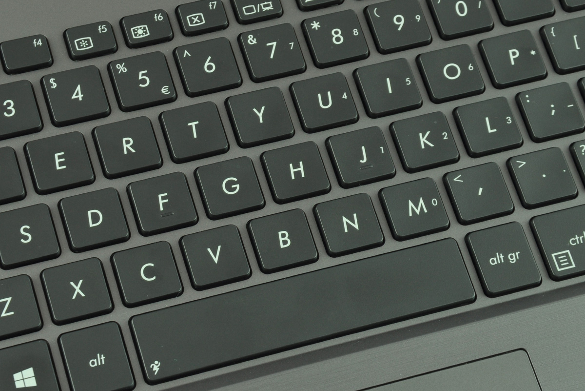 Close-up of a dark laptop keyboard showing letter keys, function keys, and the spacebar area.