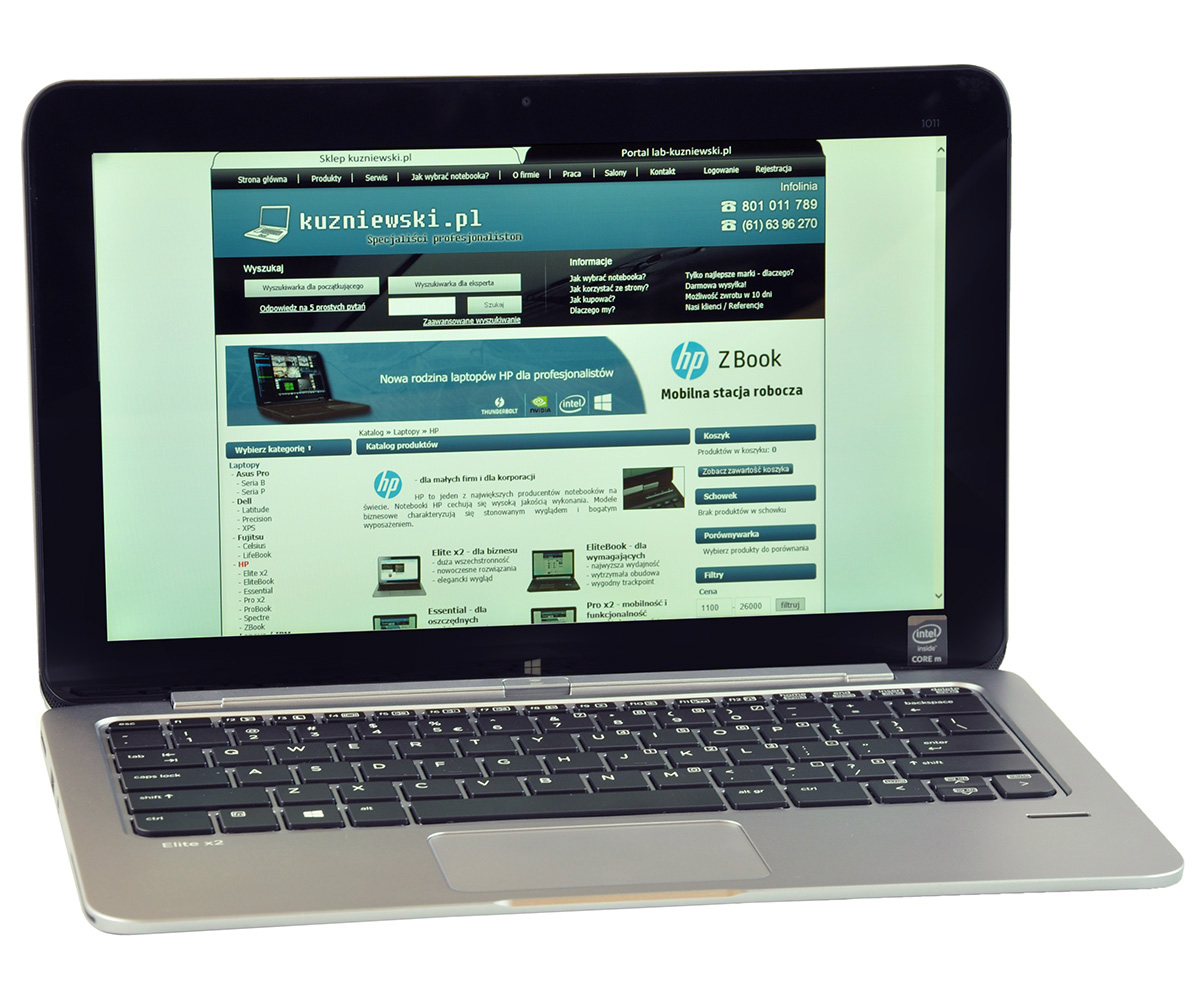 Open silver laptop displaying a Polish website on its screen, featuring a blue banner and product catalog light on a white background