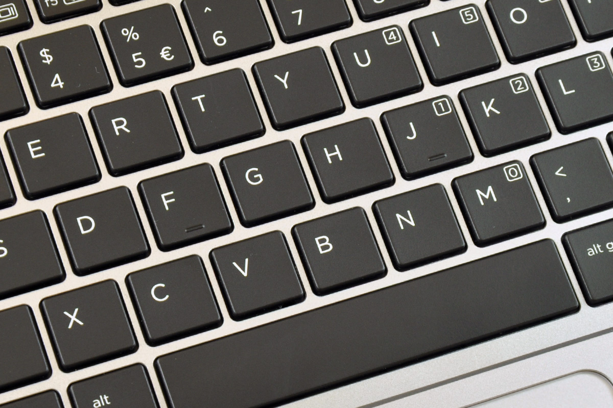 Close-up of a laptop keyboard with black keys and white letters (QWERTY layout).
