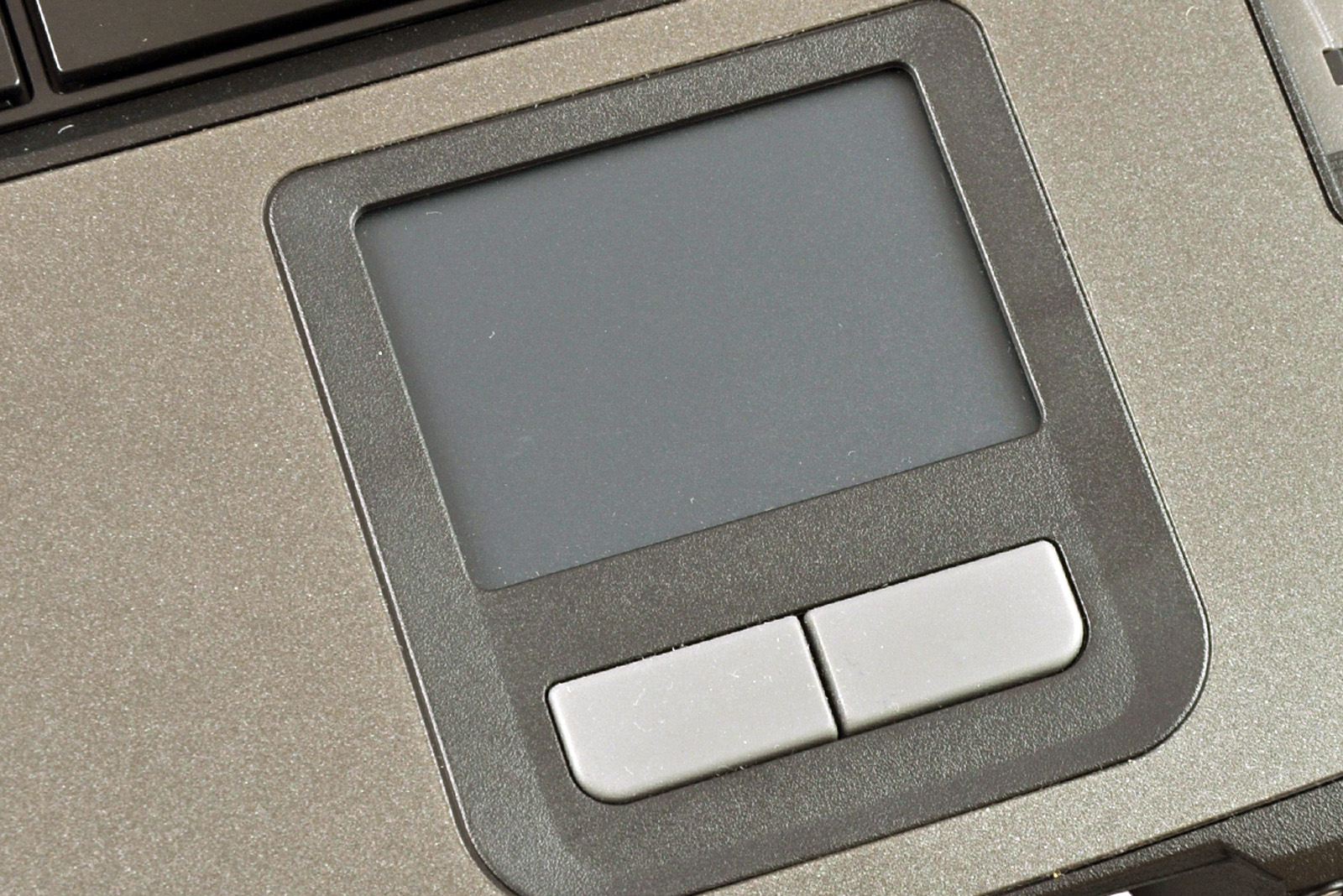 laptop-getac-b300-6_1 - lab-kuzniewski.pl - Testy laptopów, recenzje i porównania Close-up of a laptop touchpad with two rectangular buttons below a square, matte surface panel.