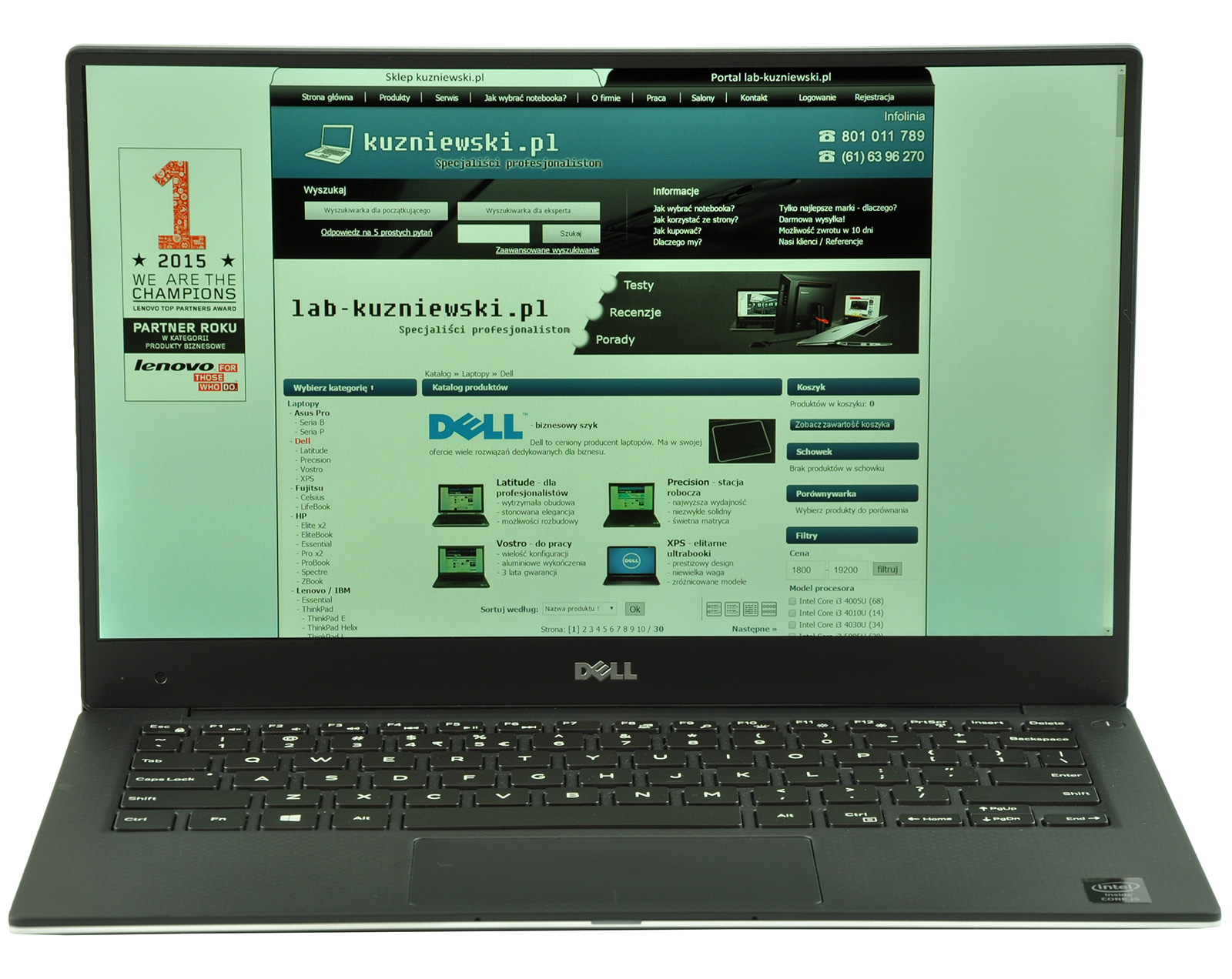 Open Dell laptop displaying a Polish tech website with a green-blue layout and Dell branding on screen.
