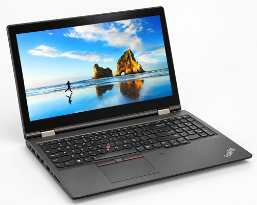 thinkpad_yoga15_2019_poradnik_lab - lab-kuzniewski.pl - Testy laptopów, recenzje i porównania Open black Lenovo ThinkPad laptop on a white background, screen showing a beach wallpaper with rock formations and blue sky.