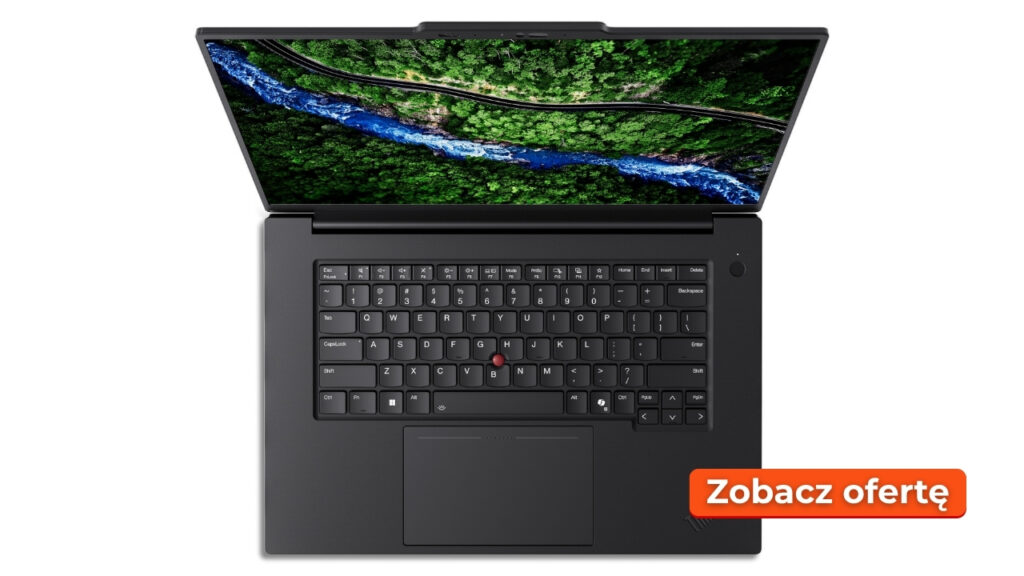 Top-down view of a dark gray laptop open with a forest wallpaper on the screen; an orange badge in the bottom-right reads 'Zobacz ofertę'.