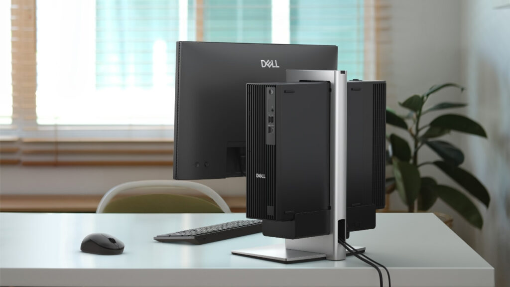 Dell Pro Slim All-in-One OSS25_3008_0001 - lab-kuzniewski.pl - Testy laptopów, recenzje i porównania Dell desktop with two upright monitors on a silver stand, keyboard and mouse on a white desk in a bright office setting