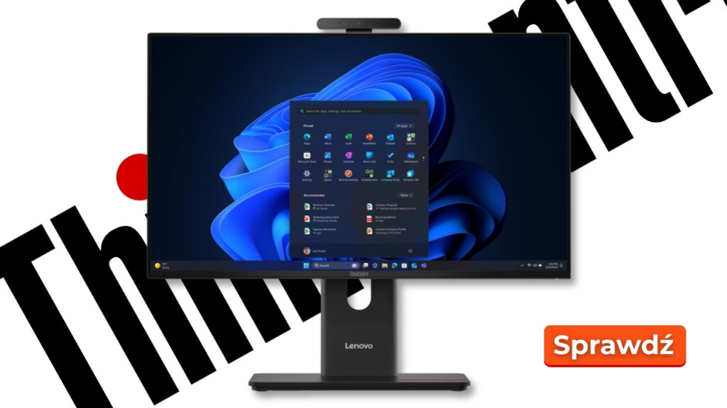 Lenovo all-in-one monitor on a stand displaying Windows 11 desktop; orange 'Sprawdź' button visible in background.