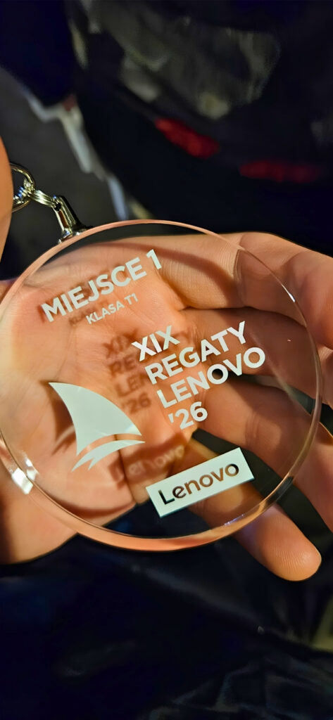 Round glass trophy with Lenovo logo and inscriptions 'MIEJSCE 1 KLASA TI' and 'XIX REGATY LENOVO' held in a hand.