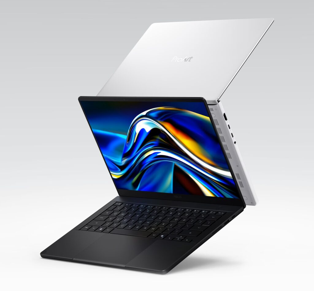 Open black laptop with a silver lid raised behind it, shown from an angled side view and a vibrant display on the screen.