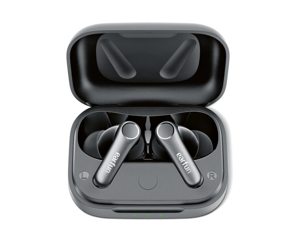 Open gray charging case containing wireless earbuds; left and right markers visible, with four green charging LEDs on the front.